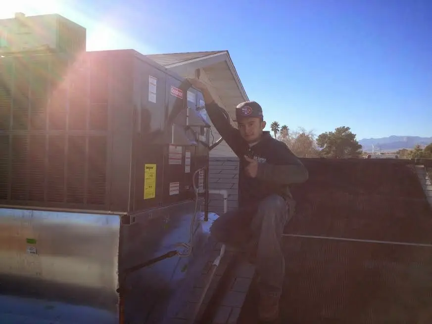 HVAC technician performing Heat Pump Repair on a rooftop unit in Lake San Marcos